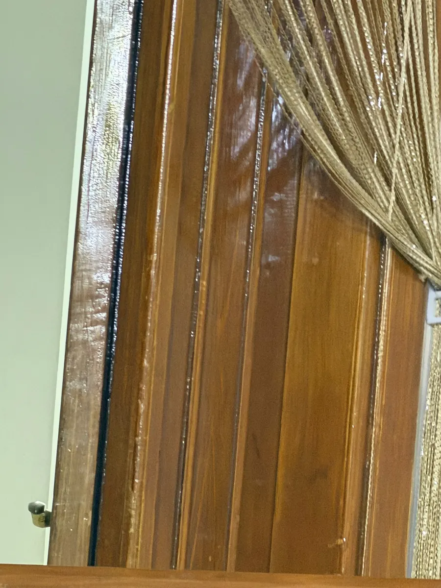 تفصيل قريب لحواف باب خشبي بعد الصنفرة وإعادة الورنيش